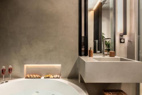 a bathroom with a bath tub and a sink at A-Loft Superior Experience in Chania Town