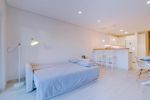 a white bedroom with a bed and a kitchen at Villa V1 Vale do Lobo Beach in Vale do Lobo