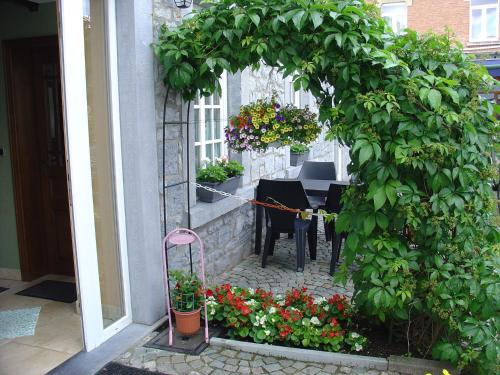 a garden with a table and flowers in front of a building at Stylish Holiday Home in Han sur Lesse with Terrace in Han-sur-Lesse