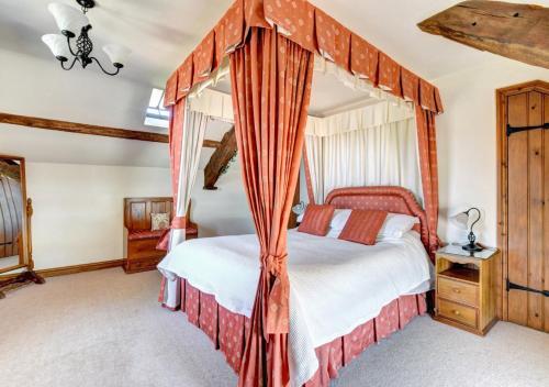 a bedroom with a four poster bed and curtains at Bwthyn Blaencar in Sennybridge