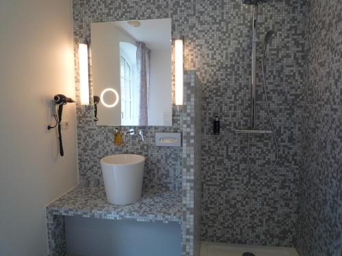 a bathroom with a shower with a sink and a mirror at Hôtel Ginkgo - SPA Biloba in Quimper