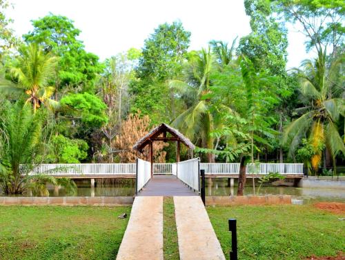 a walkway leading to a bridge in a park at Kottawatta Village in Udawalawe