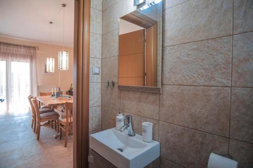 a bathroom with a sink and a mirror and a table at Saint Paul's Residences in Sani Beach
