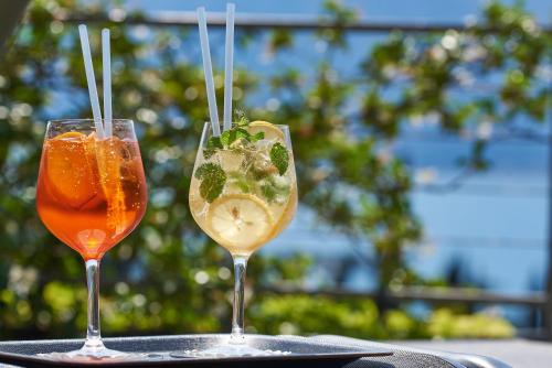 two cocktails sitting on top of a table at Hotel Villa Smeralda in Malcesine