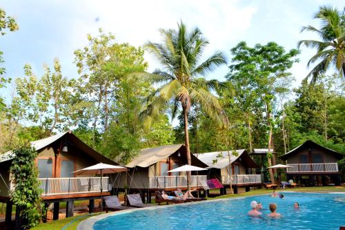 una piscina en un complejo con gente en el agua en Kottawatta Village en Udawalawe