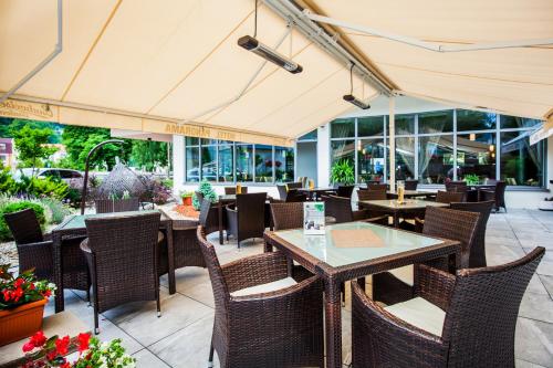 an outdoor restaurant with tables and chairs and windows at Wellness Hotel Panorama in Trenčianske Teplice