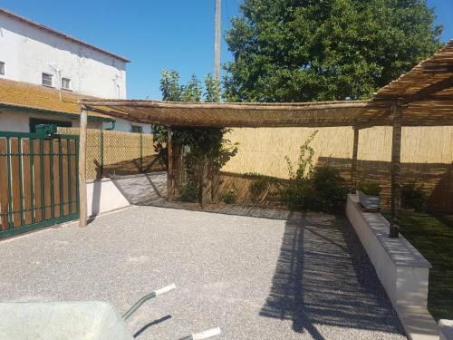 un patio trasero con una valla y una pérgola de madera en La Casetta Blu, en Capalbio
