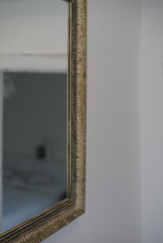 a mirror with a wooden frame on a wall at Villa Letná in Brandýs nad Labem-Stará Boleslav