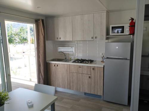 a kitchen with wooden cabinets and a white refrigerator at ReBi Village in Imperia