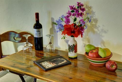 a table with a bottle of wine and a vase of flowers at Elia Hotel & Spa in Áno Voúvai