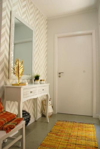 a room with a mirror and a white dressing table at Vila Maior in Sertã