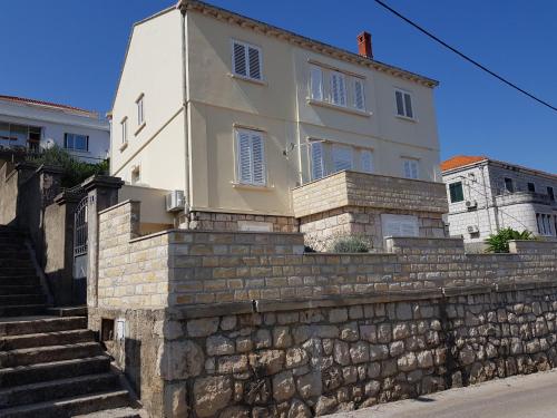 uma casa branca no topo de uma parede de pedra em Apartment Voyager em Dubrovnik