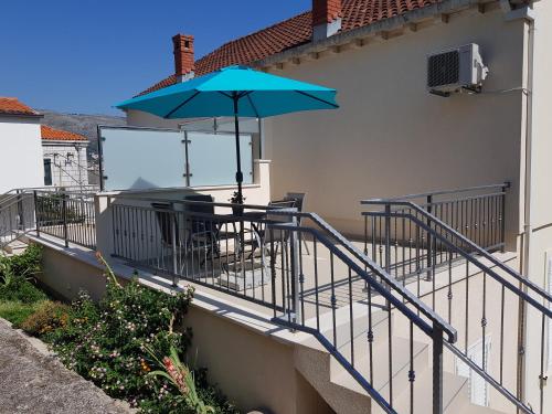 uma varanda com uma mesa e um guarda-chuva em Apartment Voyager em Dubrovnik