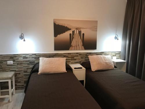 ein Zimmer mit zwei Betten und einem Gemälde an der Wand in der Unterkunft Apartamentos Los Mocanes in Puerto Rico de Gran Canaria