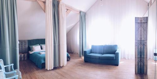 a bedroom with a blue chair and a bed at Casa Mia XIX-w Nadmorski Dom z ogrodem in Cedry Małe