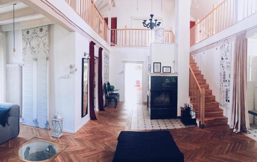 a living room with a staircase and wooden floors at Casa Mia XIX-w Nadmorski Dom z ogrodem in Cedry Małe
