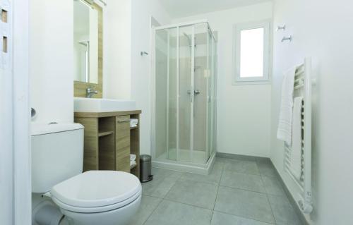 La salle de bains blanche est pourvue d'une douche et de toilettes. dans l'établissement Résidence Odalys Acqua Linda, à Poggio-Mezzana