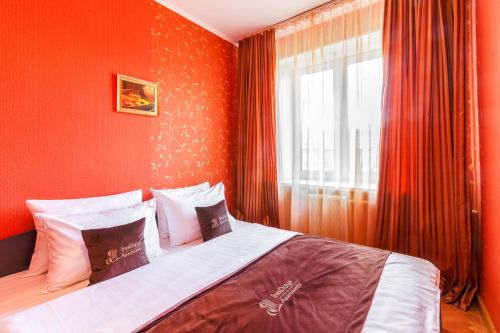 モスクワにあるInnDays on Kievskayaのベッドルーム1室(赤い壁のベッド1台、窓付)