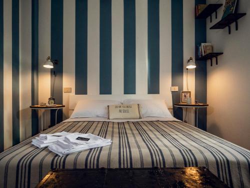 1 dormitorio con 1 cama con rayas azules y blancas en Alloggio del Fiume - Le Vecchie Vasche, en Sassa