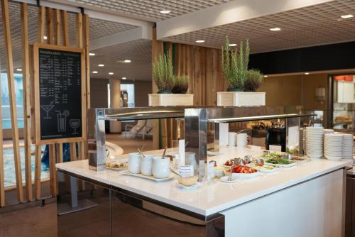 a buffet line with plates of food on a counter at Hotel Termal - Terme 3000 - Sava Hotels & Resorts in Moravske Toplice