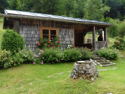 a small wooden cabin with flowers in the yard at Hilde in Lungötz