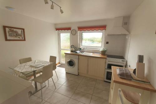 a kitchen with a table and a sink and a stove at Greyfield Farm Cottages in Farmborough