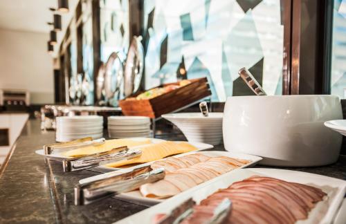 a table with plates of food on a counter at StayEasy Cape Town City Bowl in Cape Town