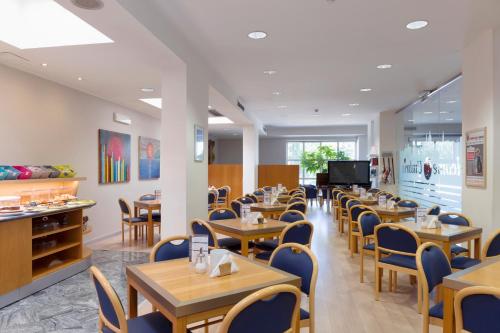 a dining room with wooden tables and chairs at City Hotel & Suites in Foligno