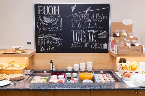 a counter with a chalk board with food on it at City Hotel & Suites in Foligno