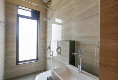 Un baño con lavabo y ventana. en StayVista at Greenwoods Villa 8 with Private Pool, Terrace, Lift & Ping-Pong Table, en Lonavala
