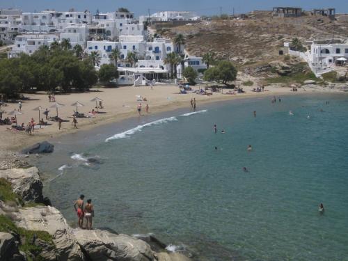 a beach with people in the water and buildings at Daphne in Naousa