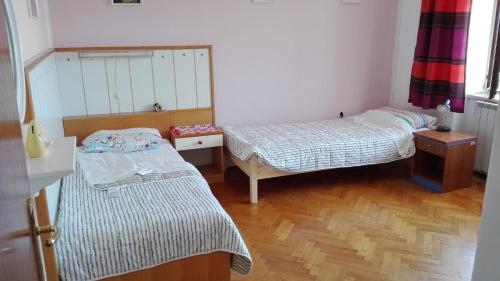 a small room with two beds and a wooden floor at ★Apartment Stella★ in Malija