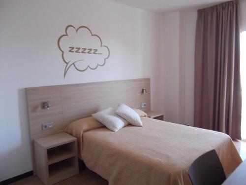 a bedroom with a bed with two pillows on it at Hotel Mediterrani Express in Calella