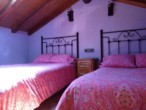 sypialnia z 2 łóżkami i drewnianym sufitem w obiekcie La Casina de Biescas w mieście Biescas