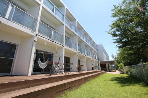 a building with a porch with a hammock on it at 365BASE outdoor hostel in Hamamatsu