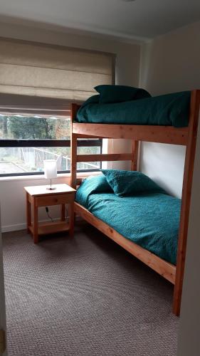 1 dormitorio con 2 literas y mesa en Amplia y Cómoda Casa, en Pucón