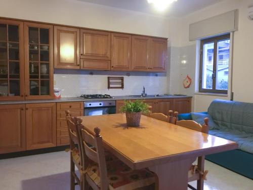 a kitchen with a wooden table and a couch at Residence del Golfo in Castellammare del Golfo