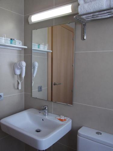 a bathroom with a sink and a mirror and a toilet at Hotel Mediterrani Express in Calella