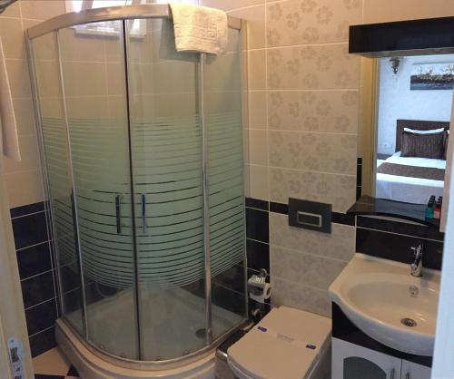 a bathroom with a shower and a toilet and a sink at Geyi̇kli̇ Sunshi̇ne Hotel in Dalyanköy