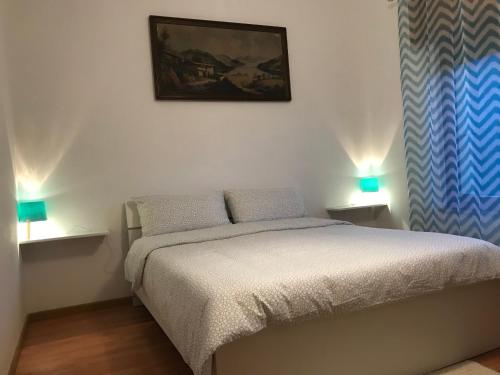 ein Schlafzimmer mit einem Bett und zwei Lampen an zwei Tischen in der Unterkunft Alloggio da Massimo in San Leonardo