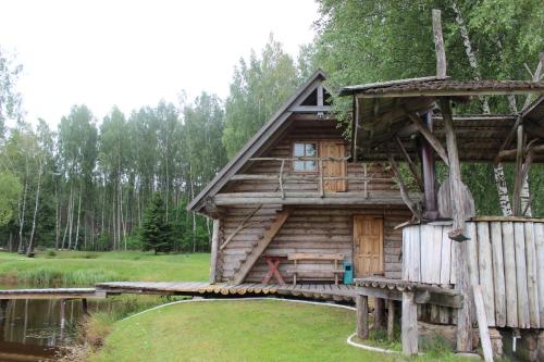 a log cabin with a porch and a wooden fence at Sodyba Vieversynė in Duokiškis