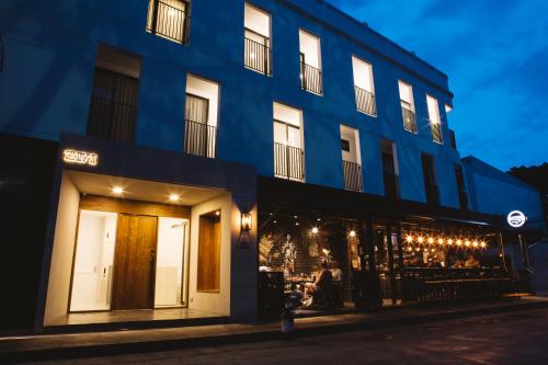 un edificio azul en una calle de la ciudad por la noche en Zivi Nimman, en Chiang Mai