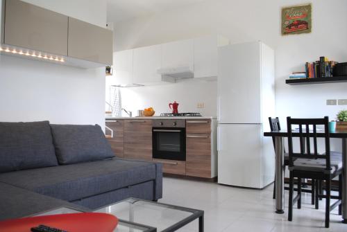a living room with a couch and a kitchen at Bnbook Cascina Crennese in Gallarate