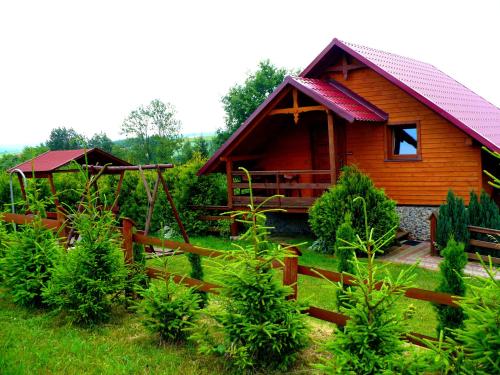 a wooden cabin with a fence in front of it at Agroturystyka ZIELONA ZAGRODA w Kosztowej in Dubiecko