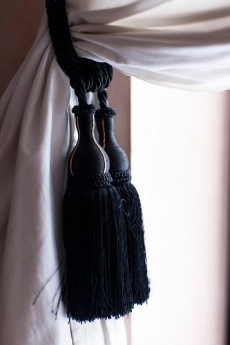 two black tassels hanging from a curtain in a window at Dar Sohane in Marrakesh