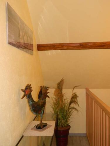 a room with a statue of a chicken next to a plant at Gite - Chambres d'Hôtes Faverolles in Faverolles
