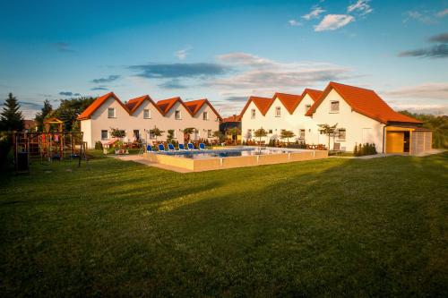 a house with a playground in a grass field at Aqua Fun Domki z Basenem in Darłowo