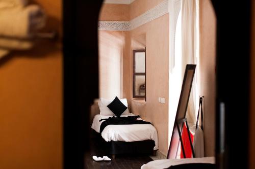 a bedroom with a bed in a room with a window at Dar Sohane in Marrakesh