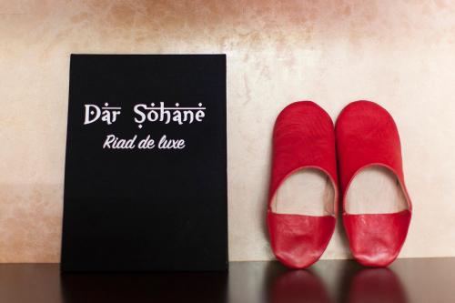 a pair of red shoes next to a black sign at Dar Sohane in Marrakesh