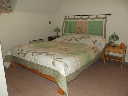 les goutilles في سانت-ماري-دي-كامبان: غرفة نوم بسرير وطاولة مع موقف ليلي